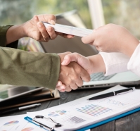 Business people shaking hands, finishing up meeting. businessman giving money to his partner while making contract - bribery and corruption concepts.